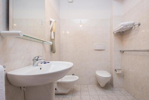 uma casa de banho branca com um lavatório e um WC em Hotel Tasso em Camigliatello Silano