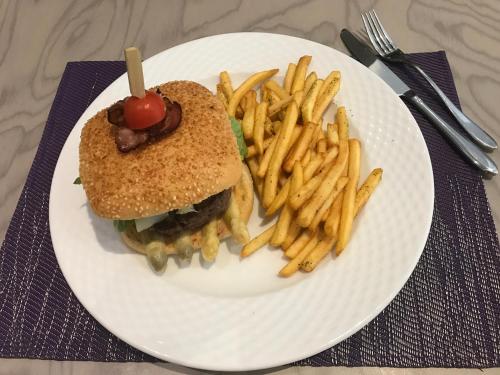 a white plate with a sandwich and french fries at Hotel Restaurant Le Cleebourg in Rott