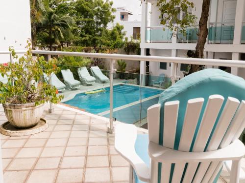 a balcony with a chair and a swimming pool at Hotel Neptuno Refugio in Boca Chica