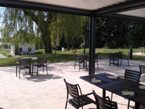 a group of tables and chairs on a patio at Hotel Restaurant Le Cleebourg in Rott