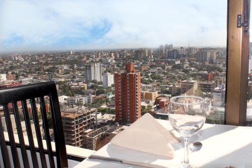 a wine glass sitting on a table with a view at Hotel Barranquilla Plaza in Barranquilla