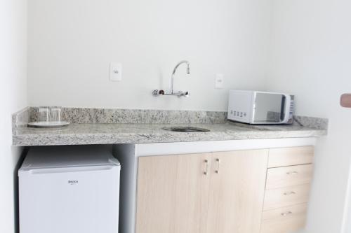 a kitchen counter with a sink and a microwave at The World Indaiatuba in Indaiatuba