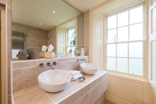 a bathroom with two sinks and a window at Cavens Country House in Kirkbean