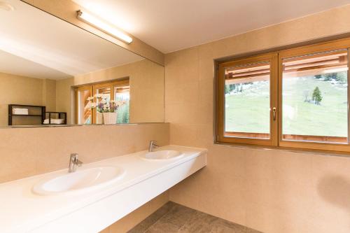 a bathroom with two sinks and a window at UALM Untermarkter Alm in Imst