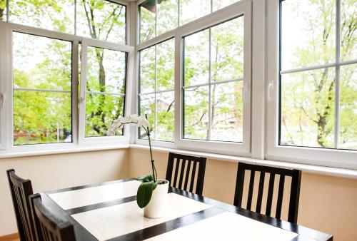 jadalnia ze stołem i czterema oknami w obiekcie Red Brick Apartments w Kłajpedzie