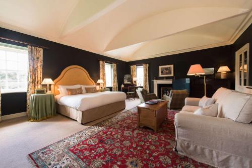 1 dormitorio con 1 cama y 1 sofá en Cavens Country House, en Kirkbean