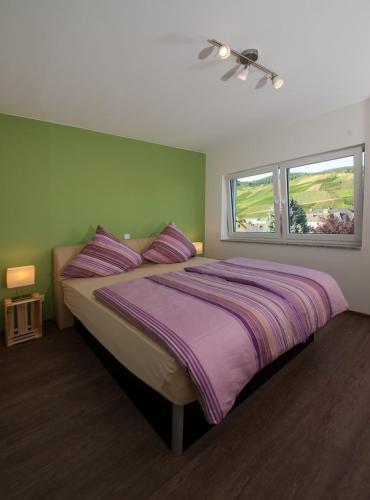 a bedroom with a large bed with a purple blanket at Gästehaus Vinaria in Kinheim