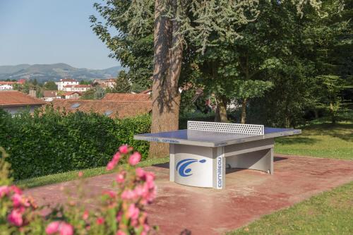 a ping pong table sitting in the middle of a yard at Residence Le Parc d'Arradoy - maeva Home in Uhart-Cize