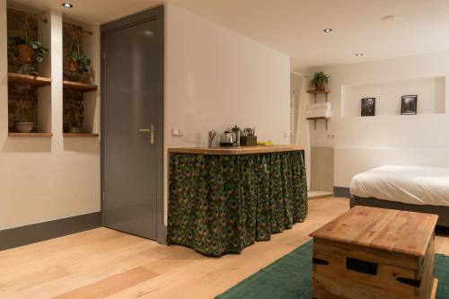 a room with a bed and a kitchen with a counter at Saint Claire Studio in Amsterdam