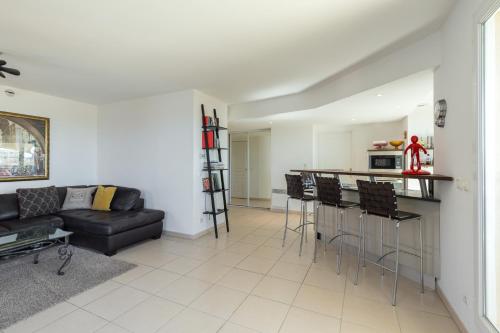 un salon avec un canapé noir et une cuisine dans l'établissement Superb penthouse in centre of Cannes Stunning views air-conditioning internet Near the Palais 532, à Cannes