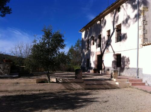 an old white building with stairs and a tree at Masía La Safranera in Alcoy
