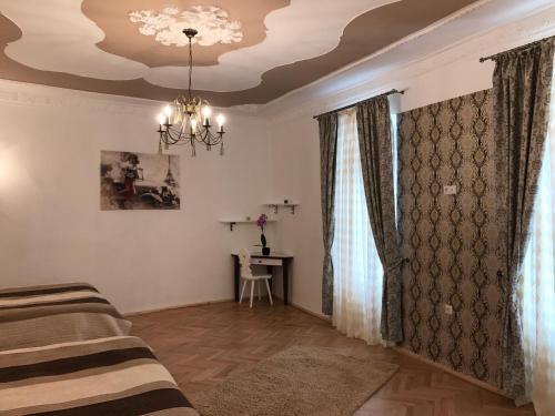 uma sala de estar com uma cama e um lustre em Turnului Apartment Central Sibiu em Sibiu
