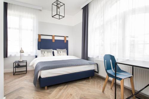 een slaapkamer met een bed, een bureau en een stoel bij Pensjonat Victoria by OneApartments in Sopot