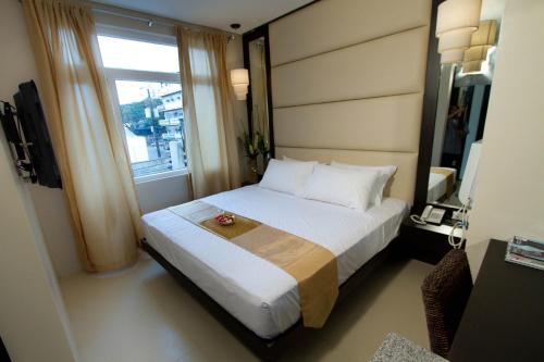 1 dormitorio con 1 cama grande y ventana en Hotel Stella, en Cebú