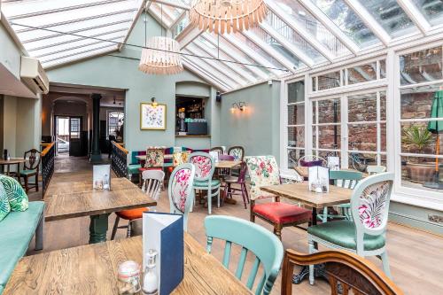 a restaurant with tables and chairs and windows at City Gate in Exeter