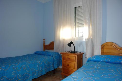 ネルハにあるCarabeo P Milenio 1 piso 2 1 sea viewの青いベッドルーム(ベッド2台、窓付)