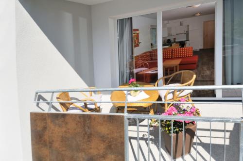 a balcony with chairs and a table with flowers at Pension Apartment Hödner in Ebbs