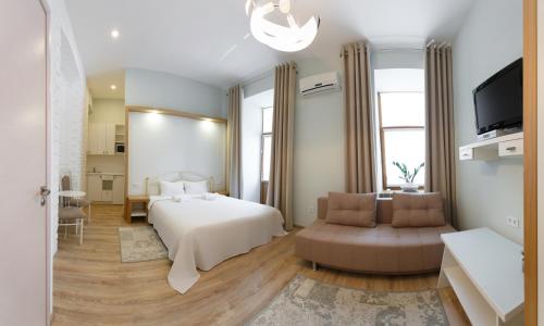 a bedroom with a bed and a couch and a tv at Basseynaya Apart Hotel in Kyiv