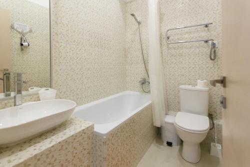 a bathroom with a toilet and a tub and a sink at Basseynaya Apart Hotel in Kyiv