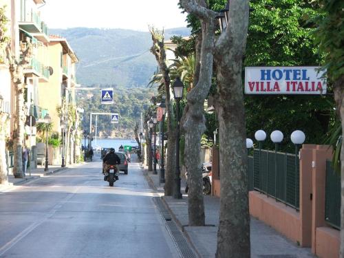 a person riding a motorcycle down a street at Hotel VILLA ITALIA B&B in Porto Azzurro