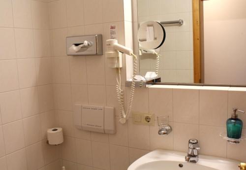 a bathroom with a hair dryer and a sink at Hotel Georgenhof in Schönau am Königssee