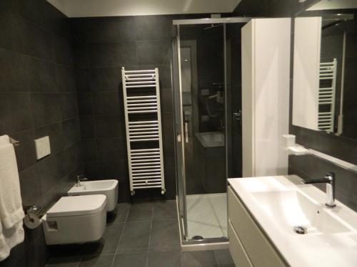 a bathroom with a toilet and a shower and a sink at RivAppartamenti in Riva del Garda