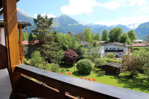 a balcony with a view of a garden and mountains at Hotel Georgenhof in Schönau am Königssee