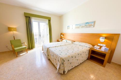 pokój hotelowy z łóżkiem i krzesłem w obiekcie Hotel Traíña w mieście San Pedro del Pinatar
