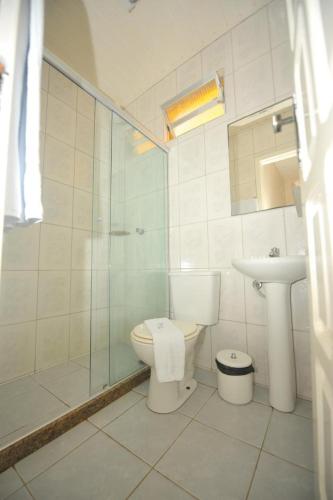 a bathroom with a toilet and a shower and a sink at Pousada Manaia in Morro de São Paulo