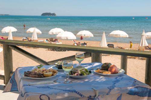 a table with food and wine glasses on the beach at Kalamaki Beach Hotel, Zakynthos Island in Kalamaki