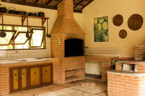 a brick oven in a kitchen with a window at Hotel Moradas do Penedo in Penedo