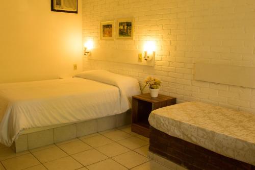 um quarto com duas camas e uma mesa e luzes em Hotel Moradas do Penedo em Penedo