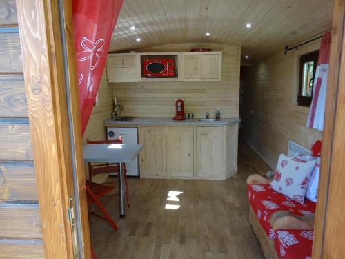 - une petite cuisine dans une petite maison avec un canapé dans l'établissement La Roulotte, à Châtillon-en-Diois