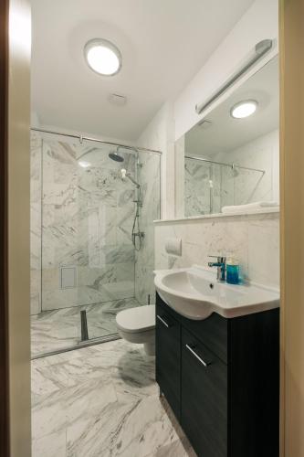 a bathroom with a toilet and a sink and a shower at YellowBoot Aparthotel in Sibiu