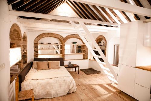 a bedroom with a bed in a room with a ladder at 1 - EL PALOMAR de TARIFA - ENJOY TARIFA in Tarifa