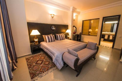 a bedroom with a large bed and a large mirror at Hôtel Des Iles in Essaouira