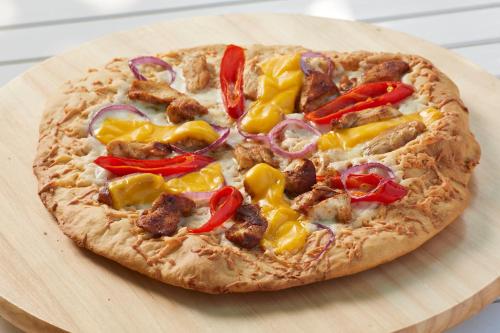 a pizza sitting on top of a wooden cutting board at Gobene Alacati in Alacati