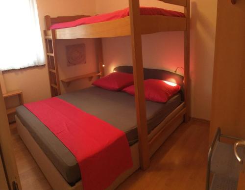 1 Schlafzimmer mit 2 Etagenbetten mit roter Bettwäsche in der Unterkunft Apartment Jurja in Povljana