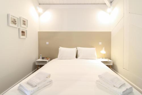 a bedroom with a large white bed with two white tables at Msc Flats in Porto