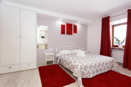 a white bedroom with a bed and red rugs at Basseynaya Apart Hotel in Kyiv