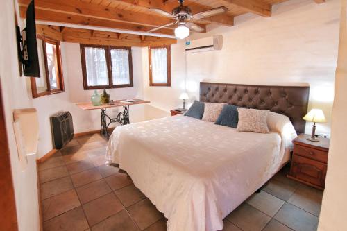 een slaapkamer met een groot bed, een tafel en een raam bij Cabañas Landhaus in Villa General Belgrano
