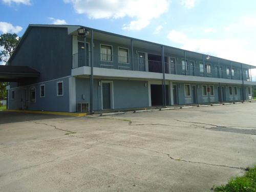 a large building with a parking lot in front of it at Super 6 Inn in Carencro