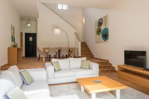 a living room with a white couch and a table at T3 Vila dos Principes in Amoreira