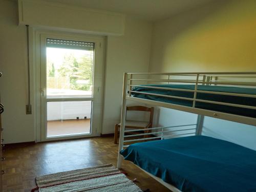 Zimmer mit 2 Etagenbetten und einem Fenster in der Unterkunft Appartamento Anna in Desenzano del Garda