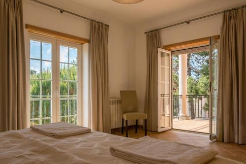 a bedroom with a bed and a sliding glass door at T3 Vila dos Principes in Amoreira