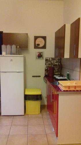 a kitchen with a white refrigerator and a trash can at Hostel Imbir in Toruń