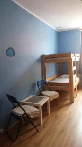 a room with two bunk beds and a chair at Hostel Imbir in Toruń