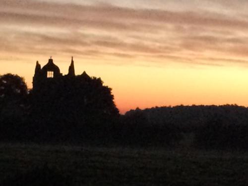 a silhouette of a building with a sunset in the background at The Old School B&B in Shawbury