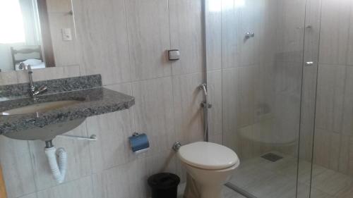 a bathroom with a shower and a toilet and a sink at Avila Hotel in Boa Esperança