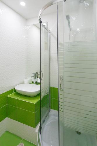 a bathroom with a sink and a glass shower at Basseynaya Apart Hotel in Kyiv
